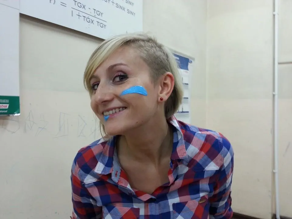 Agnieszka Kurnyta – uśmiechnięta, w klasie, z niebieską farbą na policzku